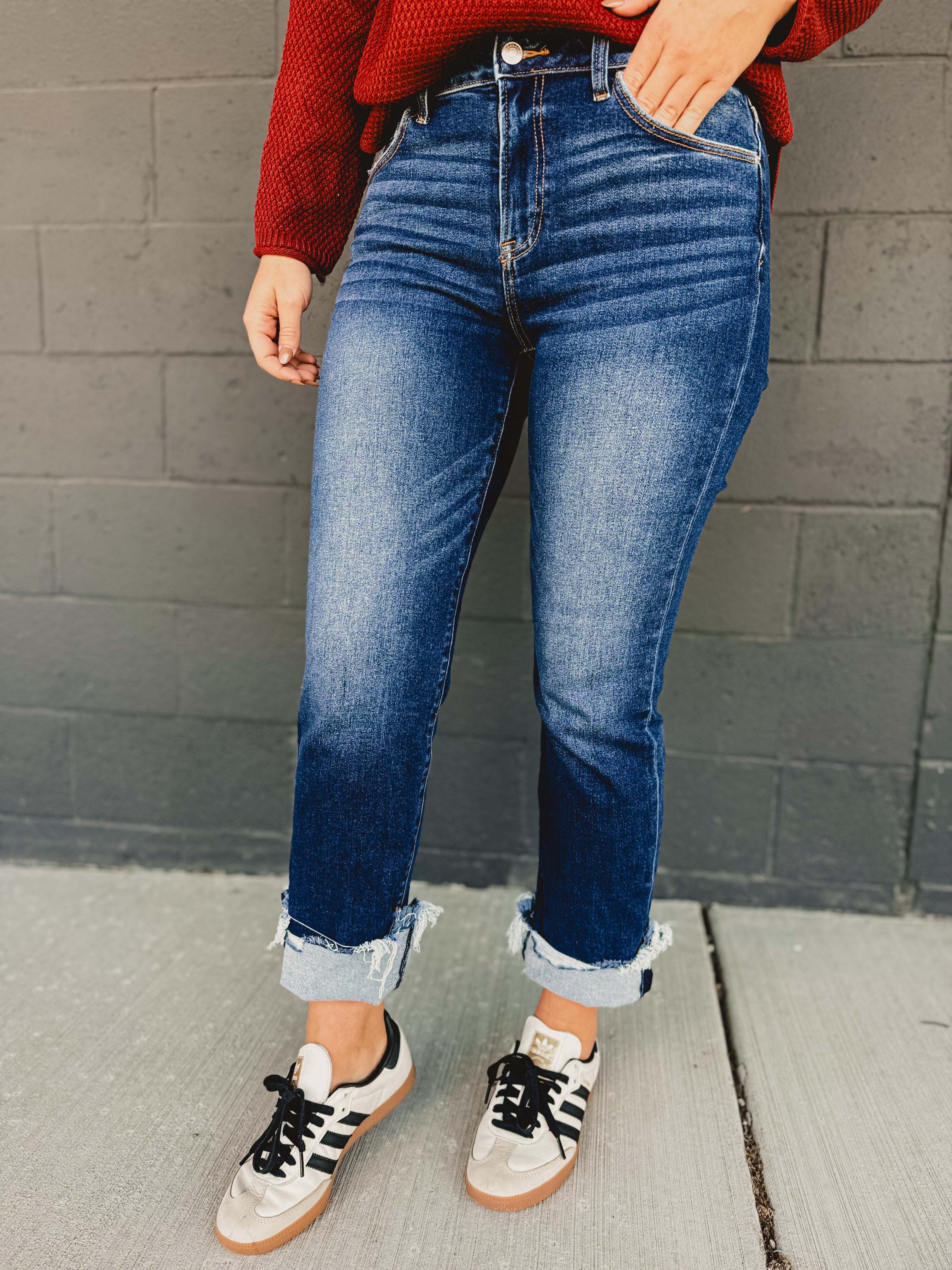 Mid-rise distressed cuffed straight leg jeans in dark denim.