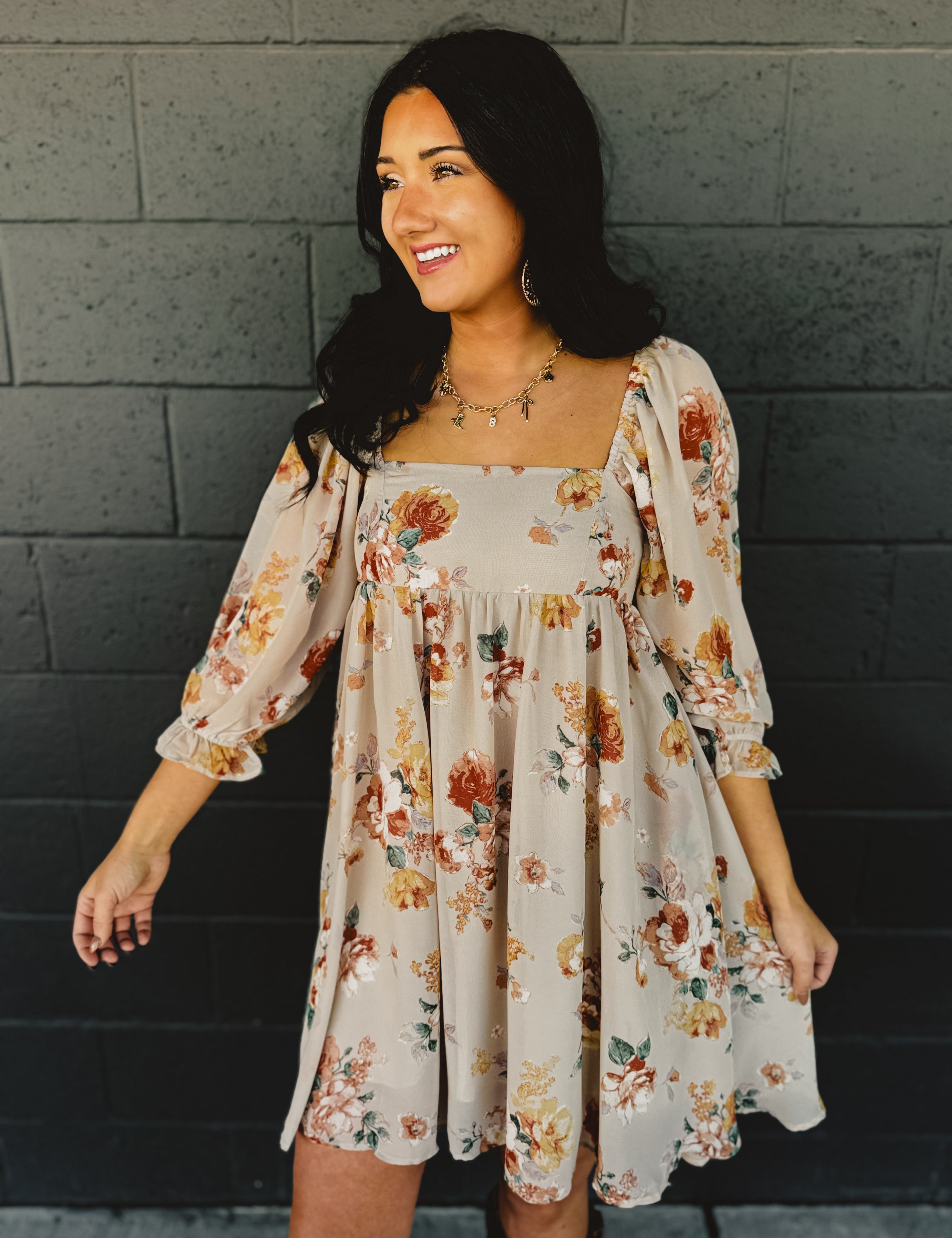 Floral printed babydoll design long sleeve mini dress with a square neckline in the color nude.
