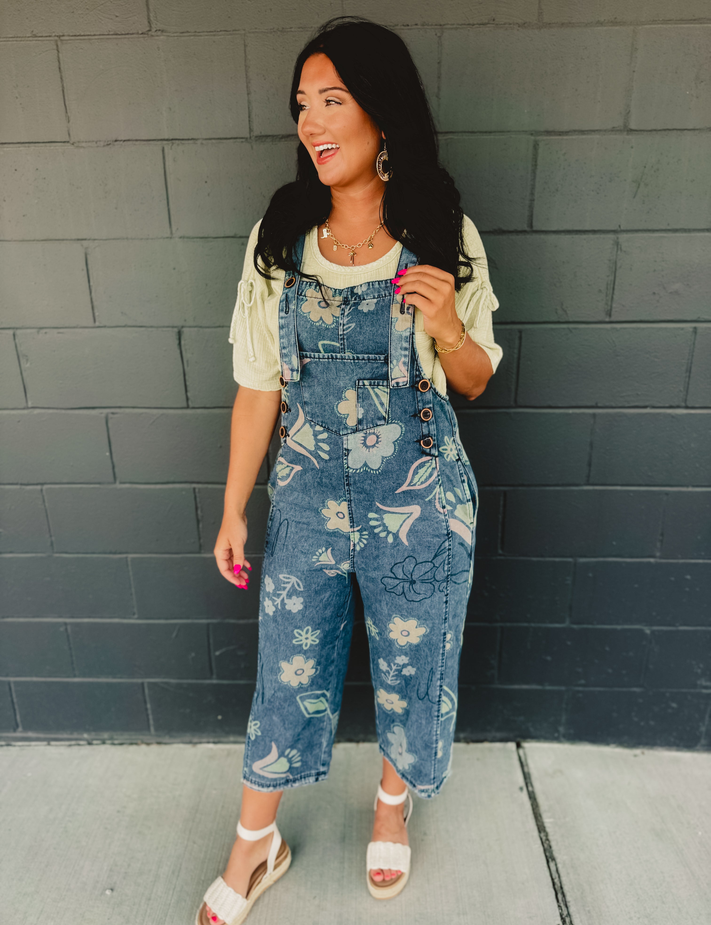 Floral printed denim cropped overalls with front pockets and chunky buttons.