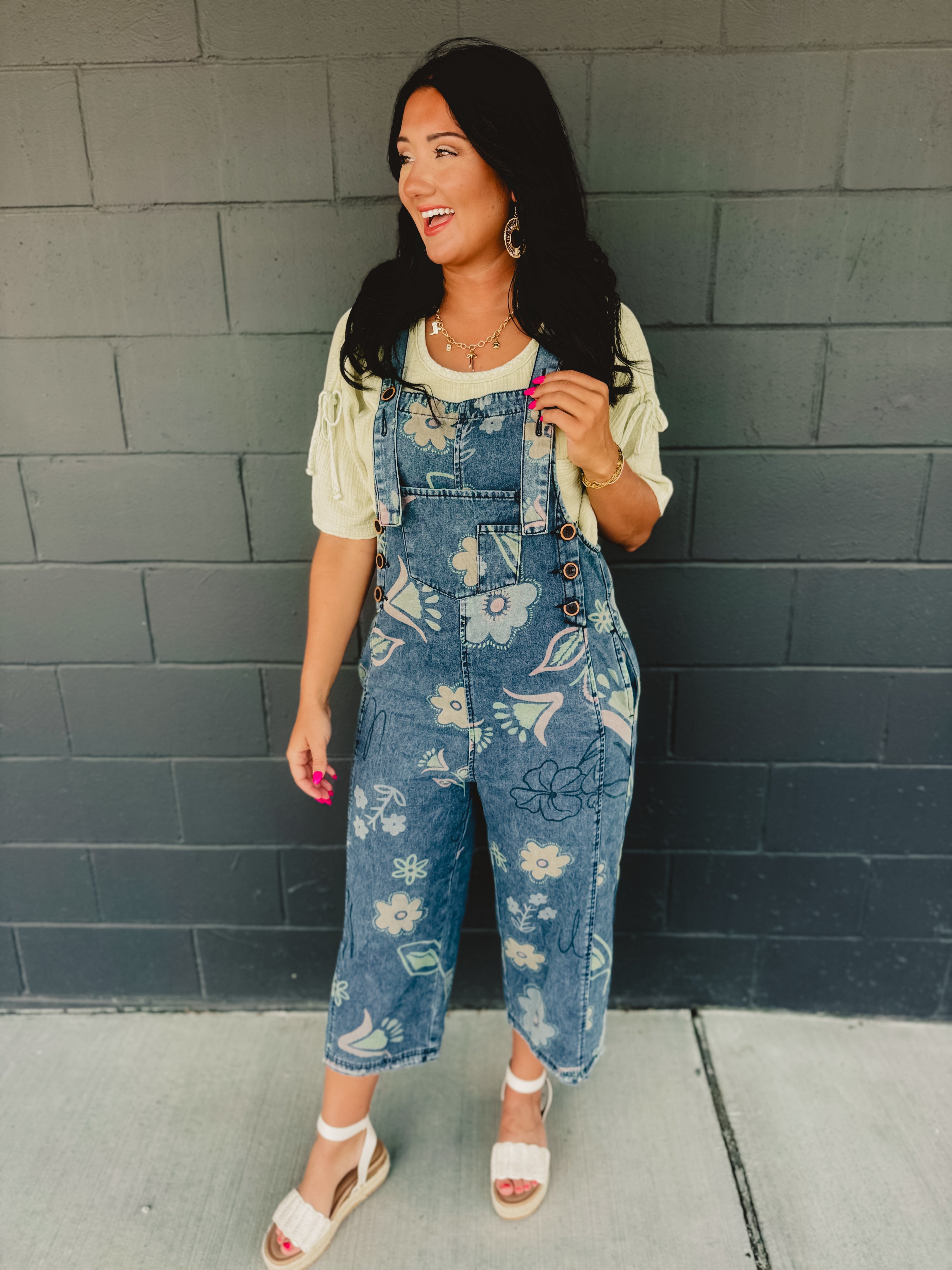 Floral printed denim cropped overalls with front pockets and chunky buttons.