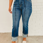 High rise-ankle wide cuffed zip-up dark denim jeans with front seam and back and front pockets.