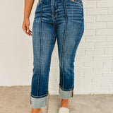 High rise-ankle wide cuffed zip-up dark denim jeans with front seam and back and front pockets.