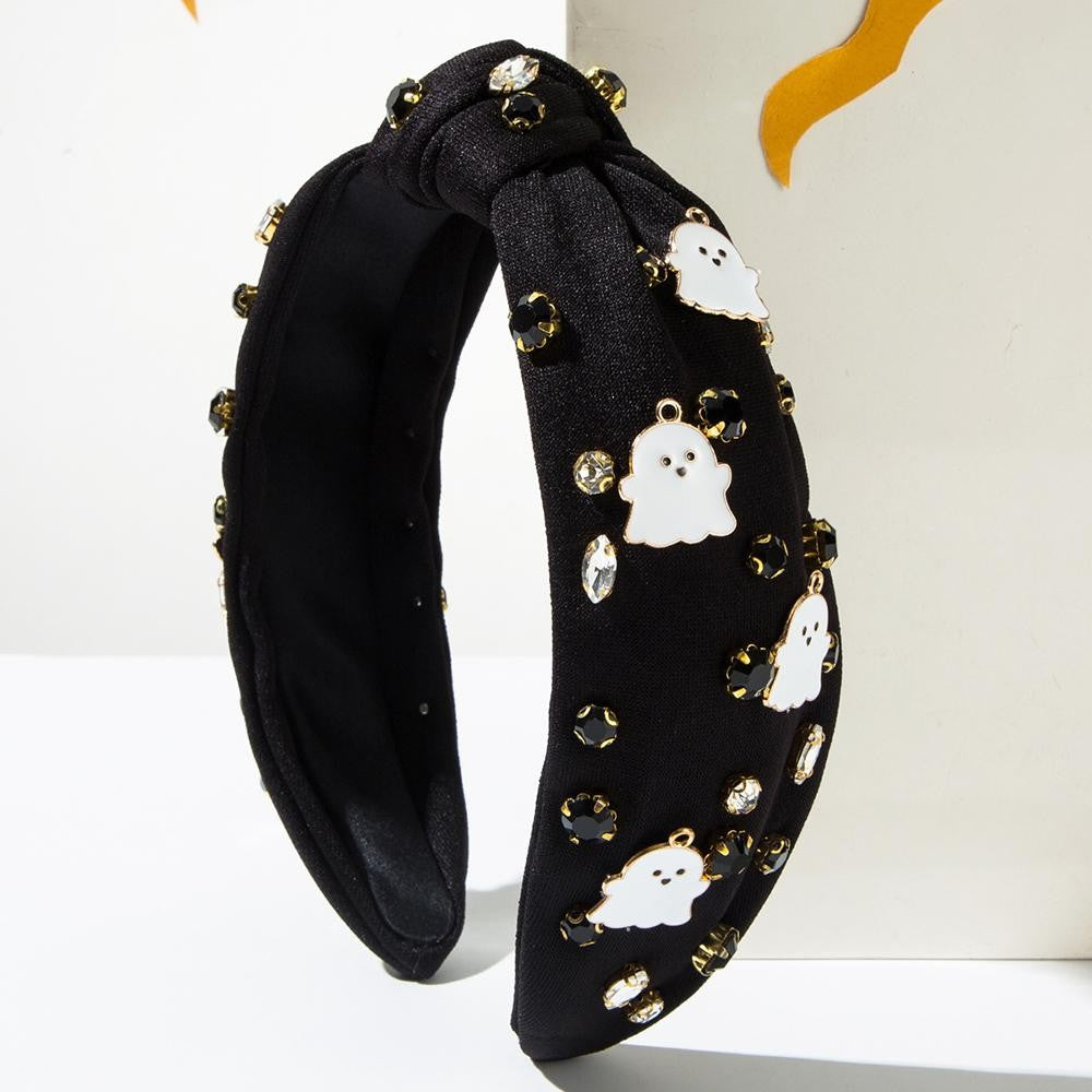 Ghost and rhinestone decorated knot headband in one size in the color black.