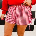 Red and white gingham boxer shorts with side tie details and an elastic waistband.