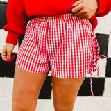 Red and white gingham boxer shorts with side tie details and an elastic waistband.