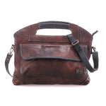 BedStu Greenway crossbody bag in teak rustic leather with black trim, showing the front flap pocket and adjustable crossbody strap