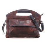BedStu Greenway crossbody bag in teak rustic leather with black trim, showing the front flap pocket and adjustable crossbody strap