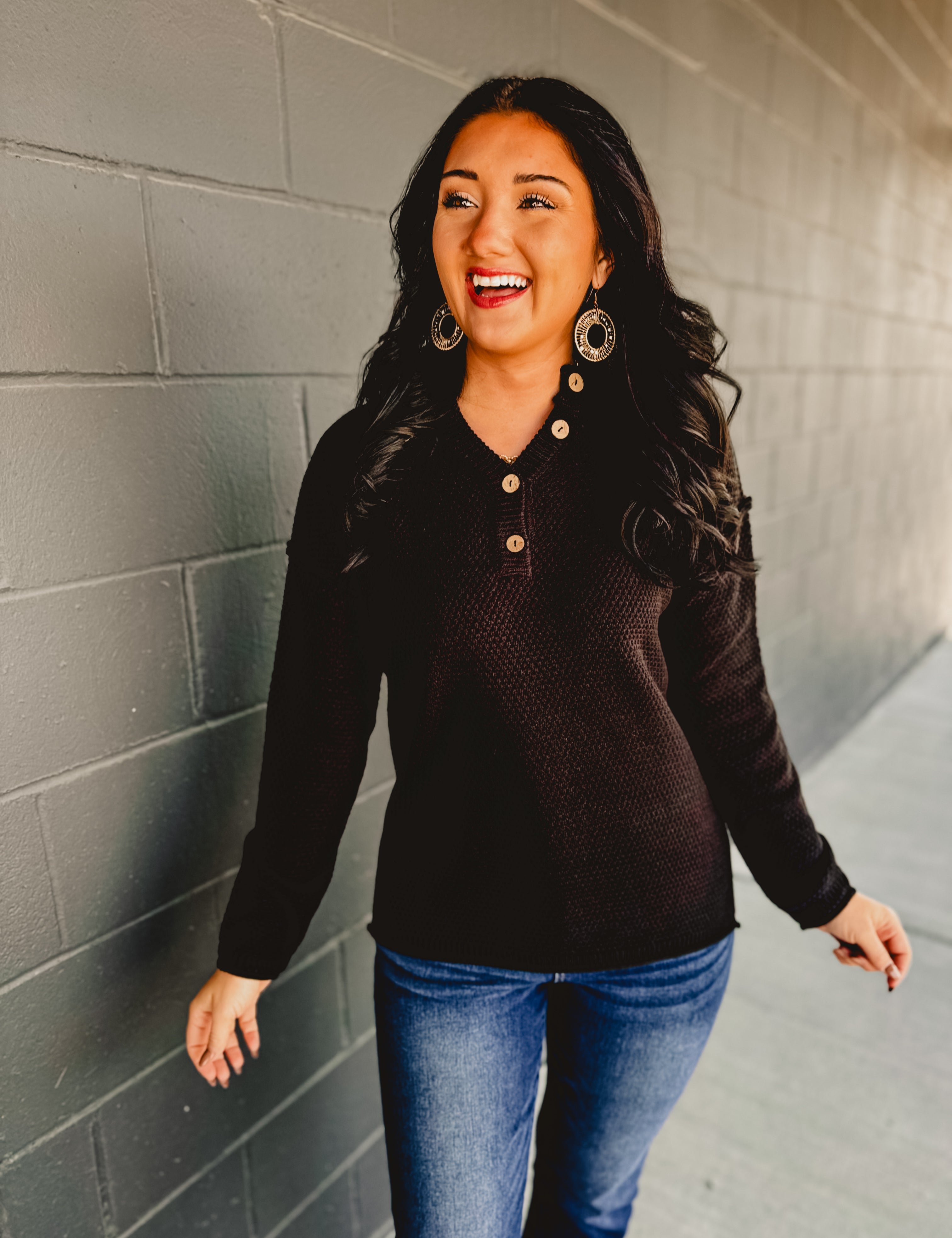 Henley neckline long sleeve waffle knit top in the color black.