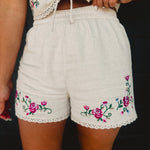 Natural high waisted shorts with floral embroidery and crochet scalloped edges.