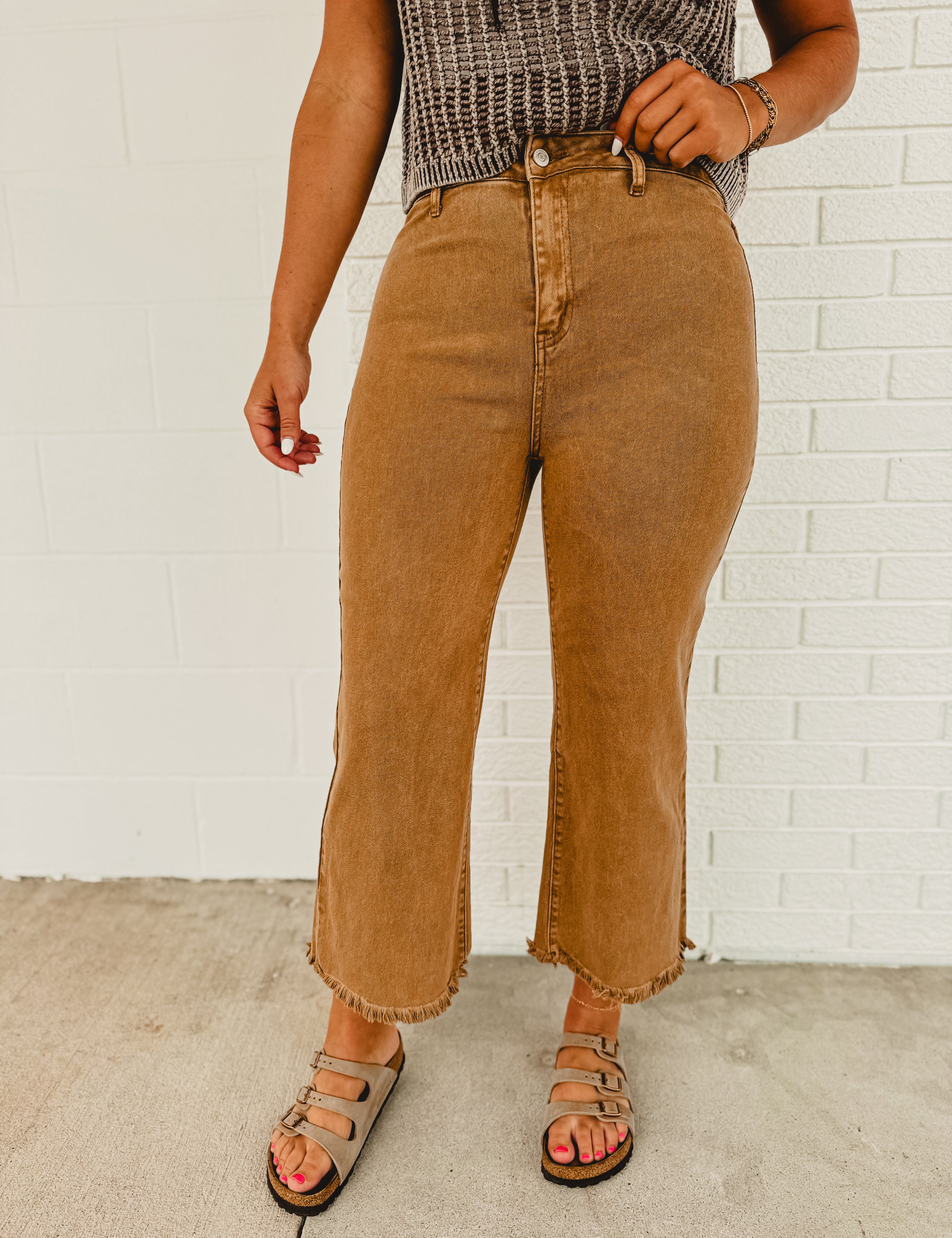 Straight cropped deep camel colored jeans with raw frayed hems.