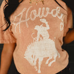 Howdy mineral washed coral colored graphic tee with short sleeves and a round neck.