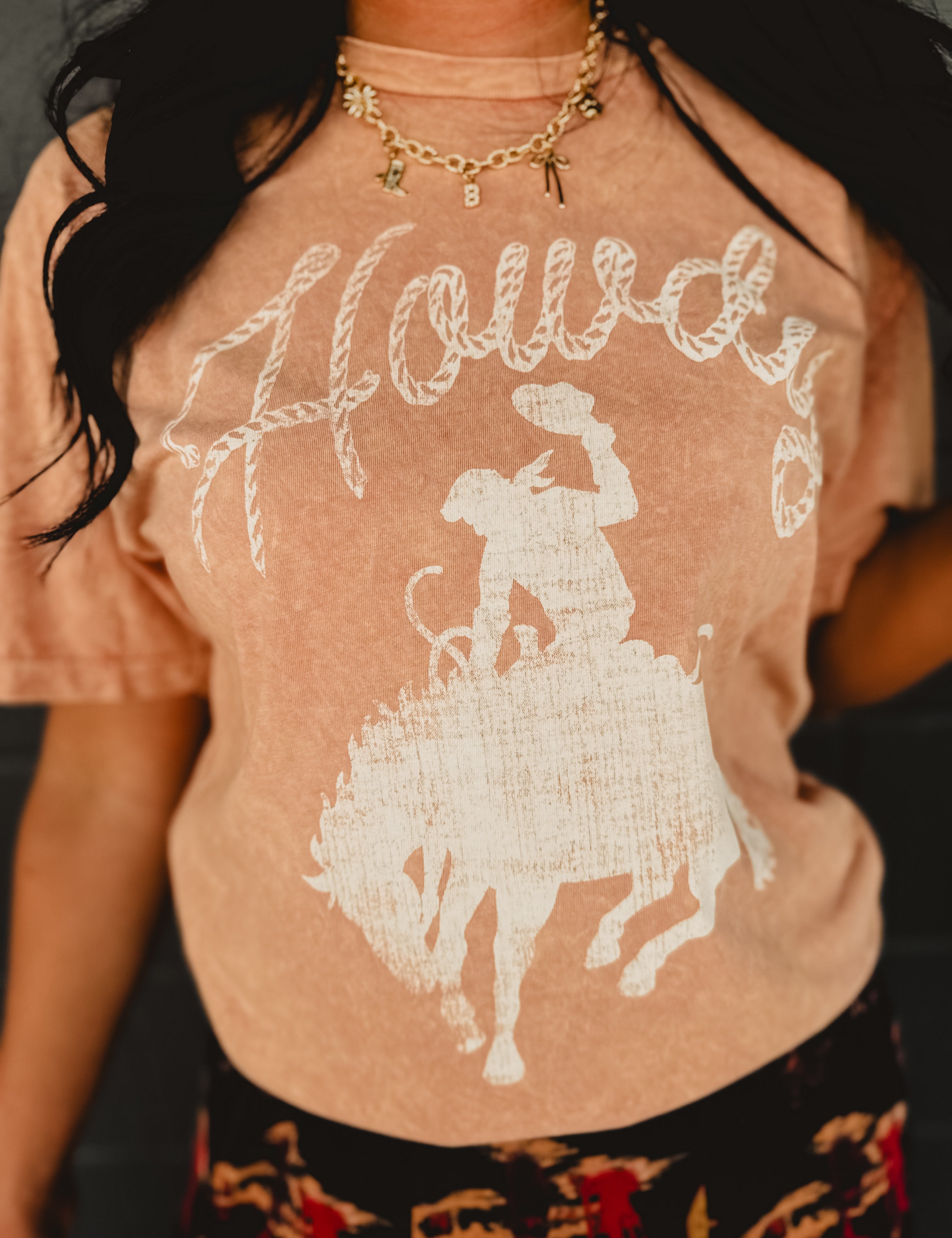 Howdy mineral washed coral colored graphic tee with short sleeves and a round neck.