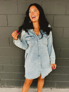 Long sleeve button up light denim mini dress with front pockets and side pockets.