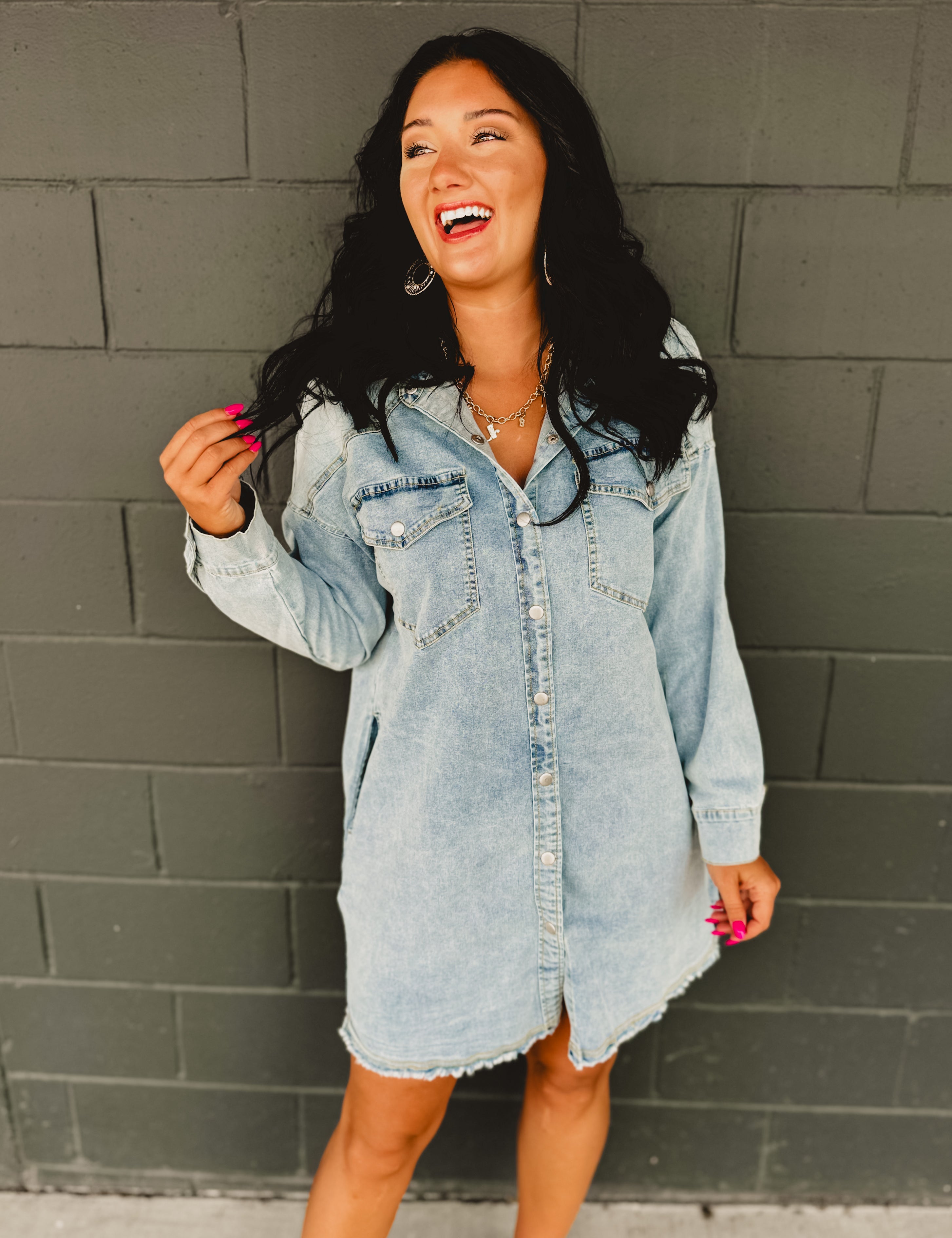 Long sleeve button up light denim mini dress with front pockets and side pockets.