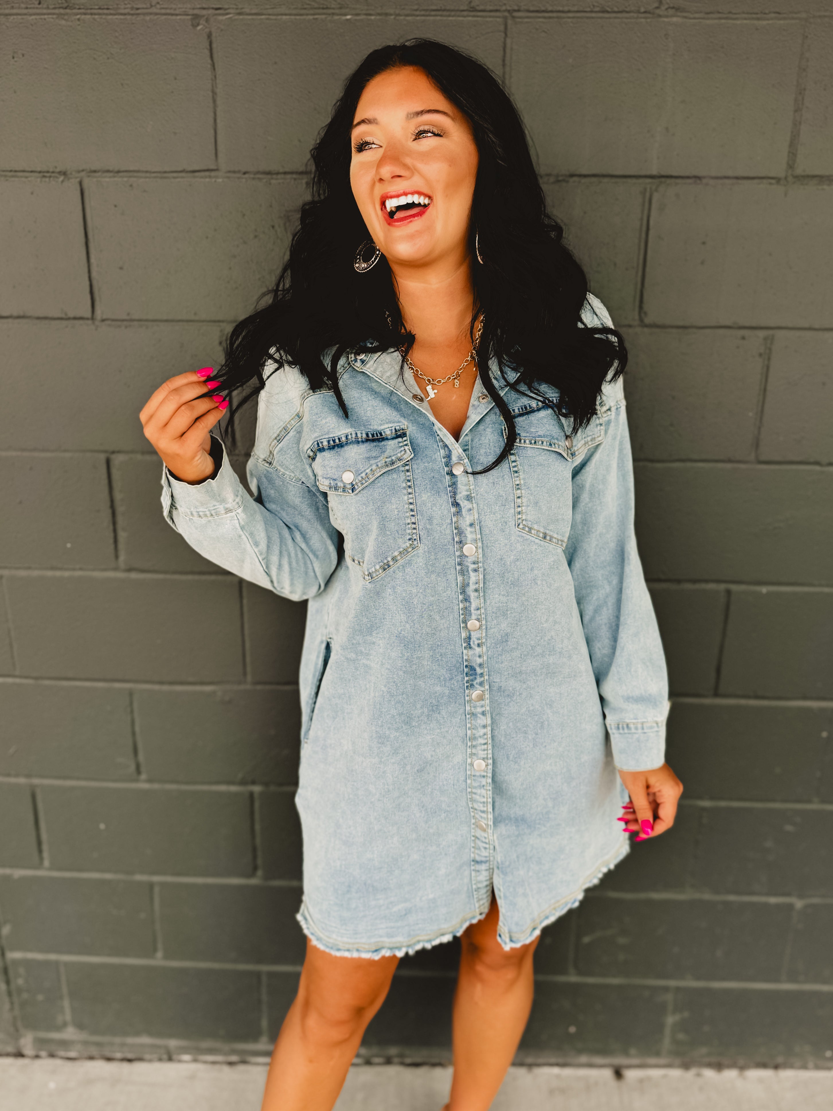 Long sleeve button up light denim mini dress with front pockets and side pockets.