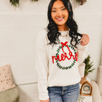 Merry wreath decorated in a bow knit fabric long sleeve sweater in white.