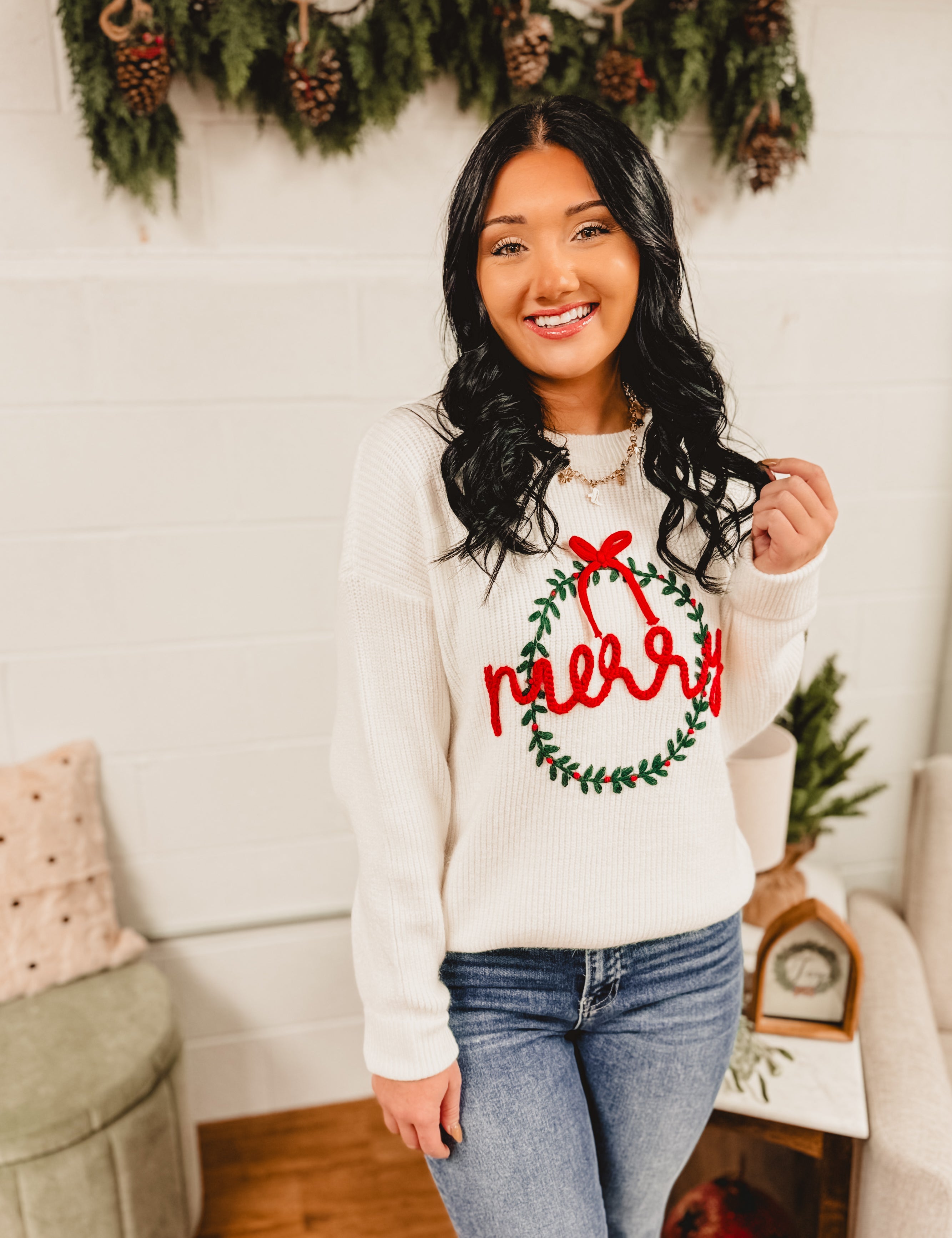 Merry wreath decorated in a bow knit fabric long sleeve sweater in white.