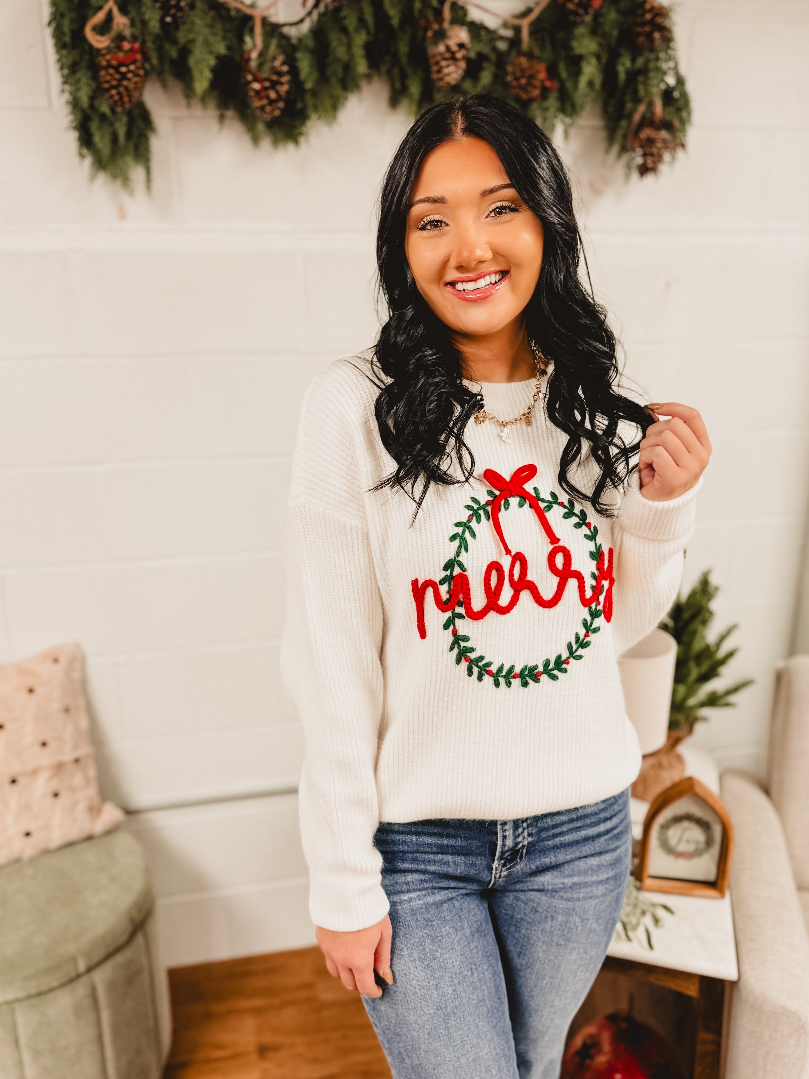 Merry wreath decorated in a bow knit fabric long sleeve sweater in white.