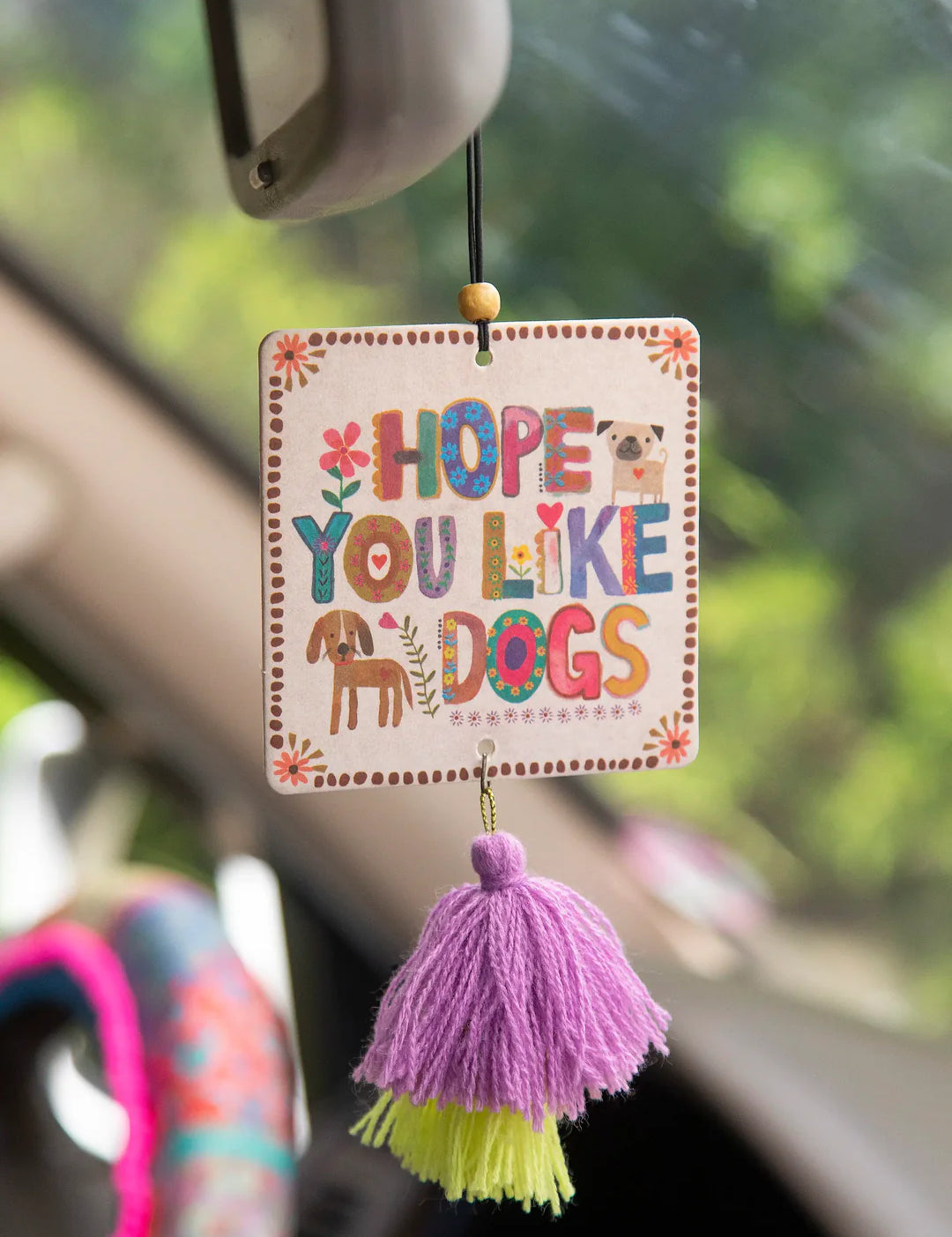 Fruity and floral essential oil scented car air freshener made by Natural Life that reads "Hope You Like Dogs."