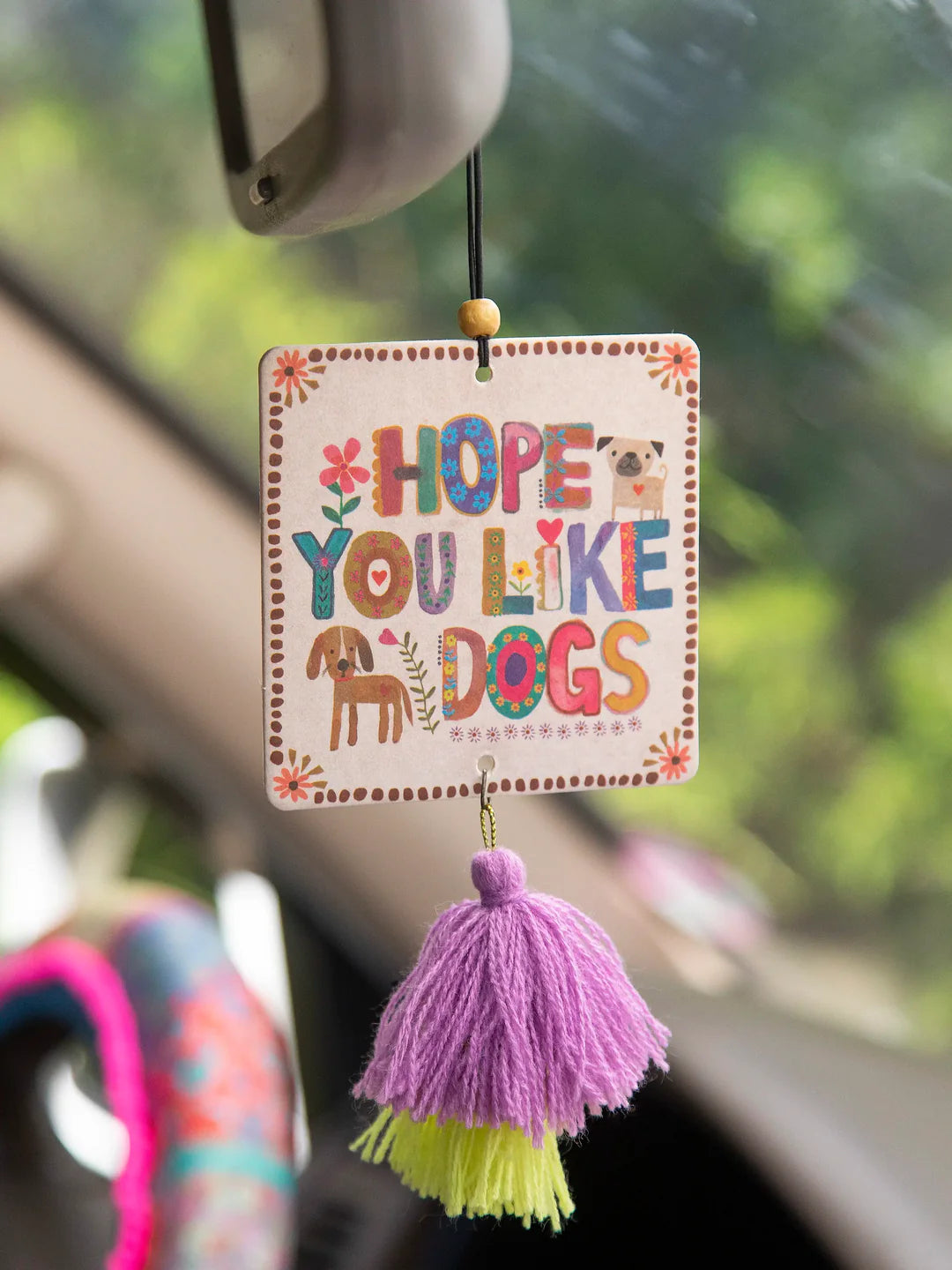 Fruity and floral essential oil scented car air freshener made by Natural Life that reads "Hope You Like Dogs."