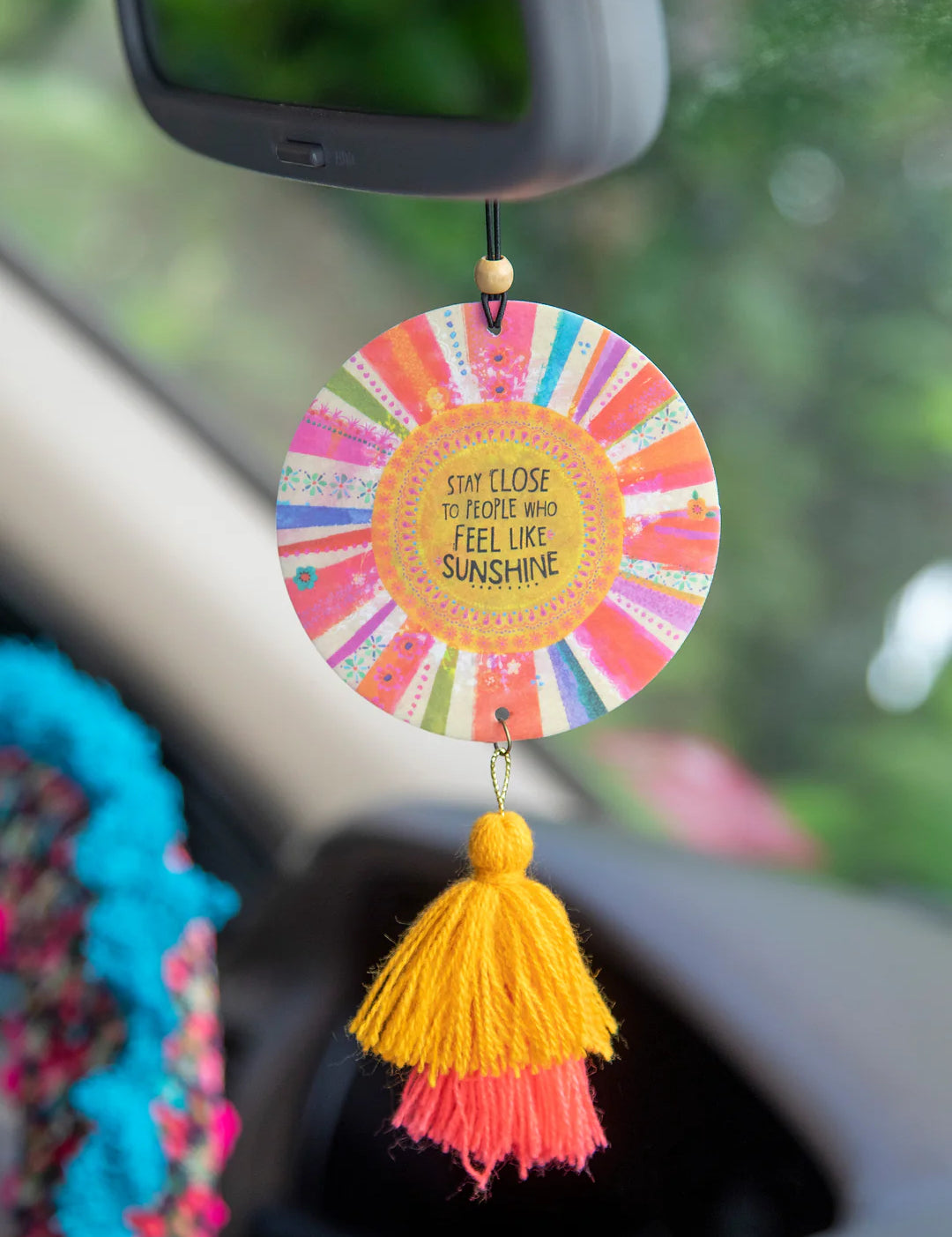 Natural Life "Stay close to people who feel like sunshine" hanging air freshener with wooden bead accent and tassels in lemon scent.