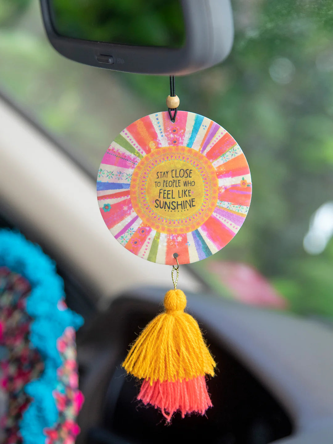 Natural Life "Stay close to people who feel like sunshine" hanging air freshener with wooden bead accent and tassels in lemon scent.