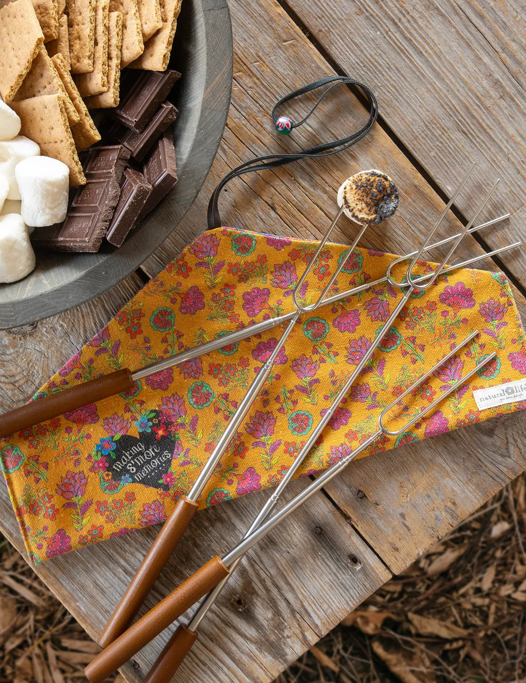 Natural Life campfire roasting sticks including a floral cloth carrier for storage that reads: "Making S'more Memories."