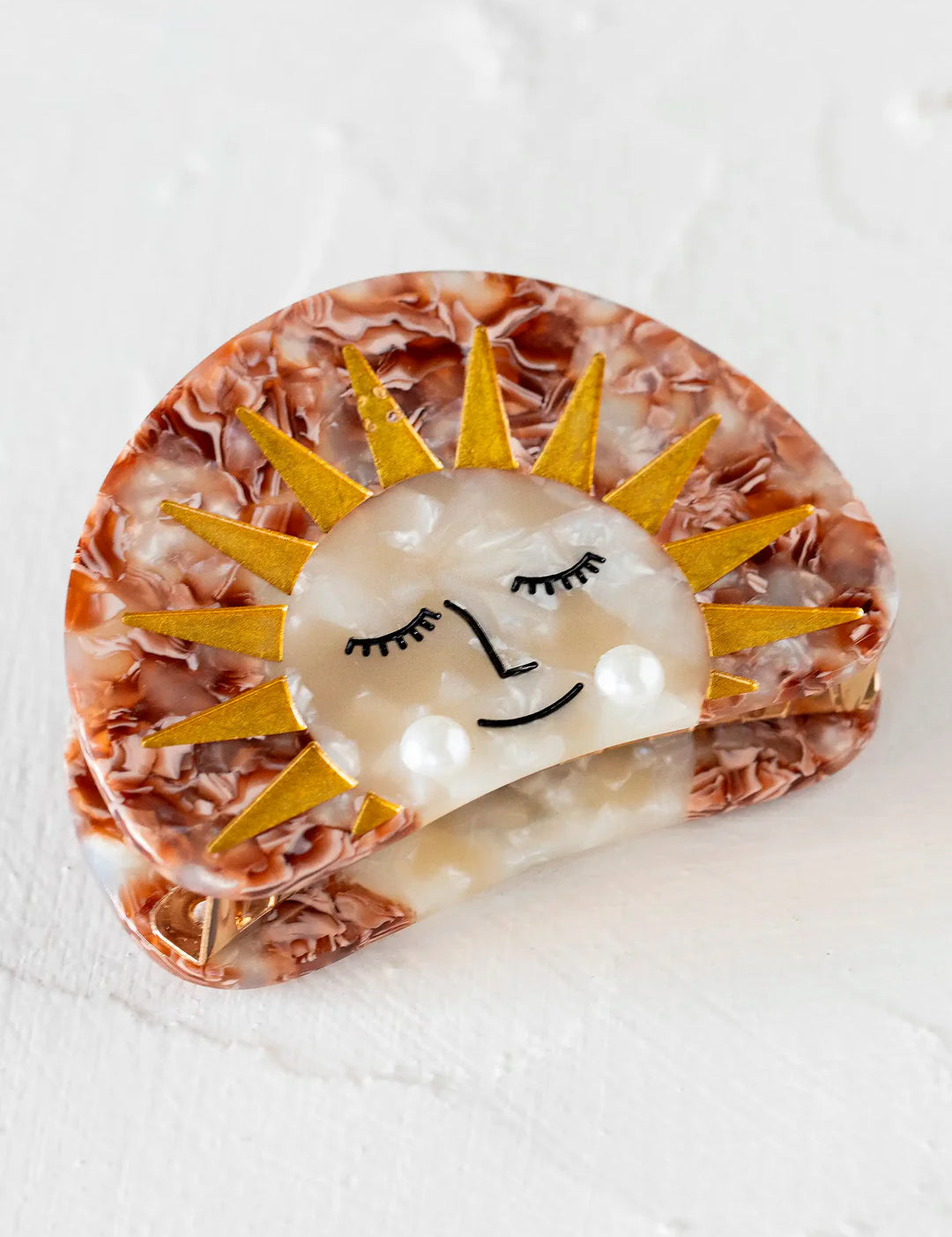 Hair clip with a sun design and pearl accents by Natural Life.