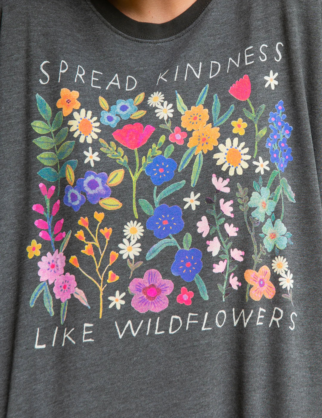 Natural Life long sleeve round neck sweatshirt that reads "Spread kindness like wildflowers," featuring side pockets and interior soft fleece.