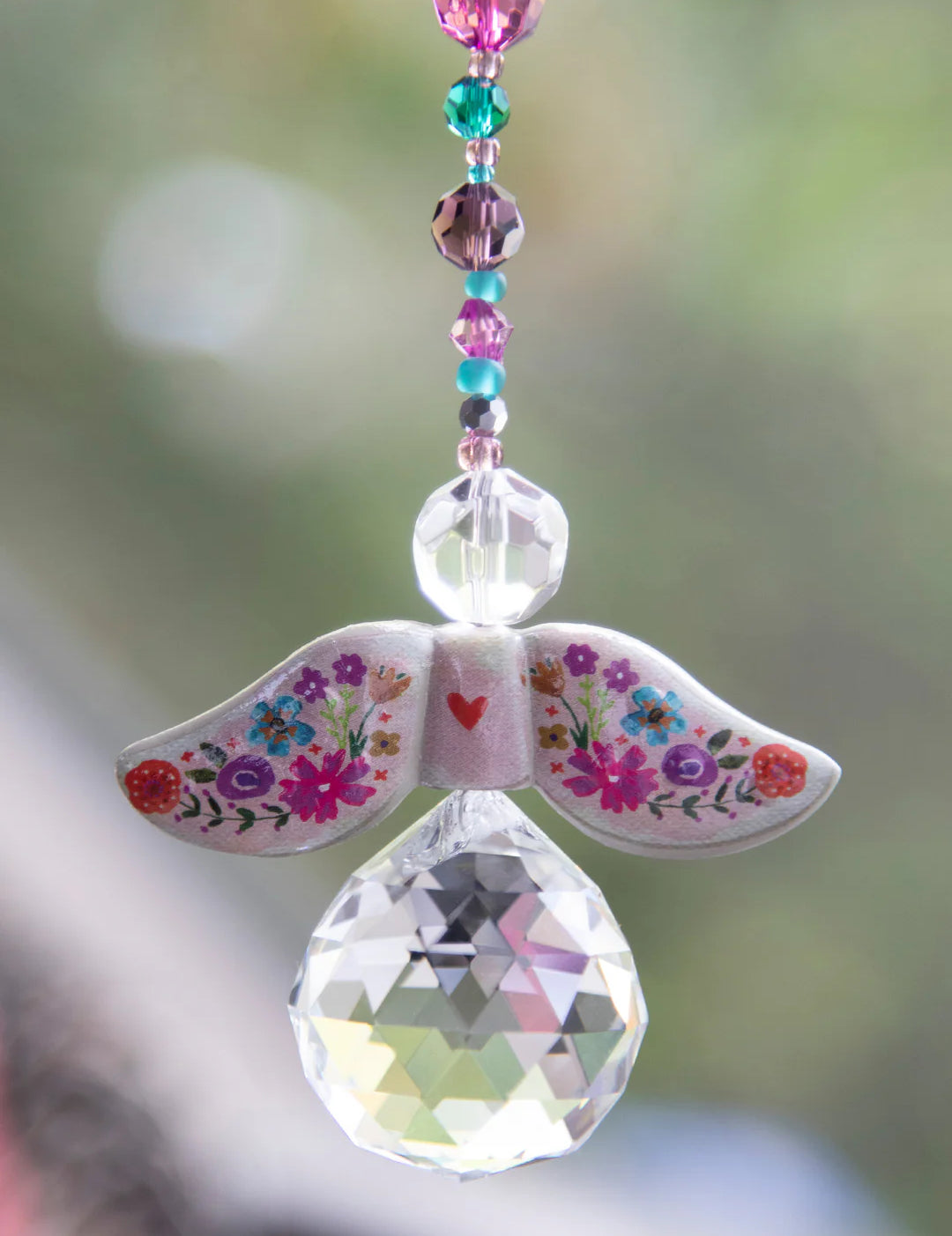 Decorative angel ornament with floral wings and a teardrop-shaped crystal by Natural Life.