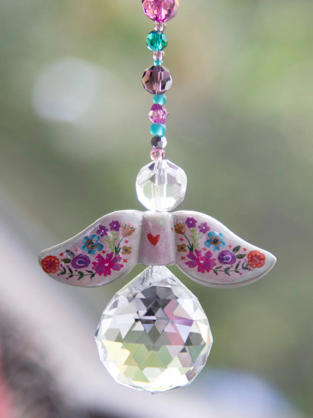 Decorative angel ornament with floral wings and a teardrop-shaped crystal by Natural Life.