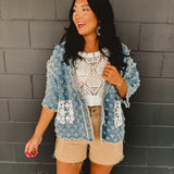 Denim holey open cardigan with white crochet pockets and a v-neck.