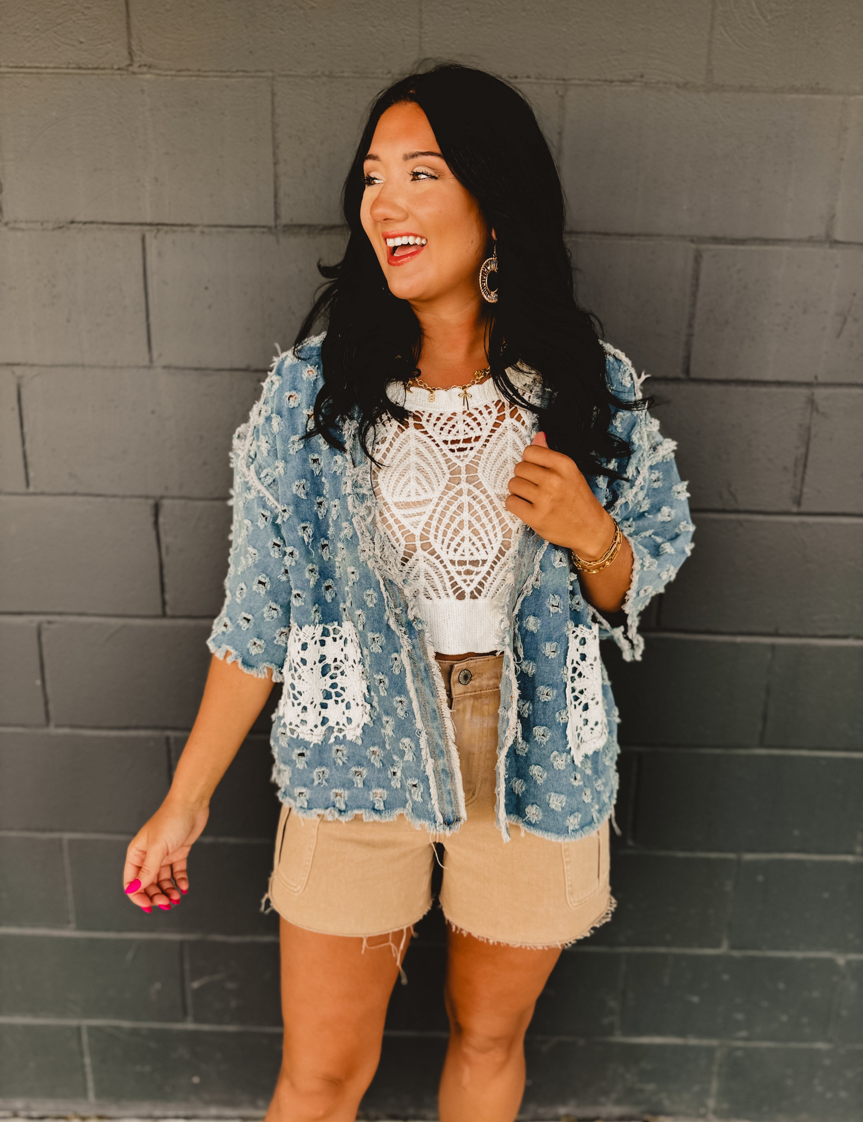 Denim holey open cardigan with white crochet pockets and a v-neck.