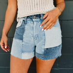 Denim patchwork shorts with zip-up closure and front and back pockets.