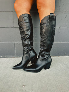Zip-up below the knee tall black embroidered western boots with pointed toes and heels.