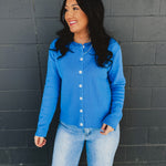 Raw rolled edge button up sweater cardigan with a round neckline in blue.