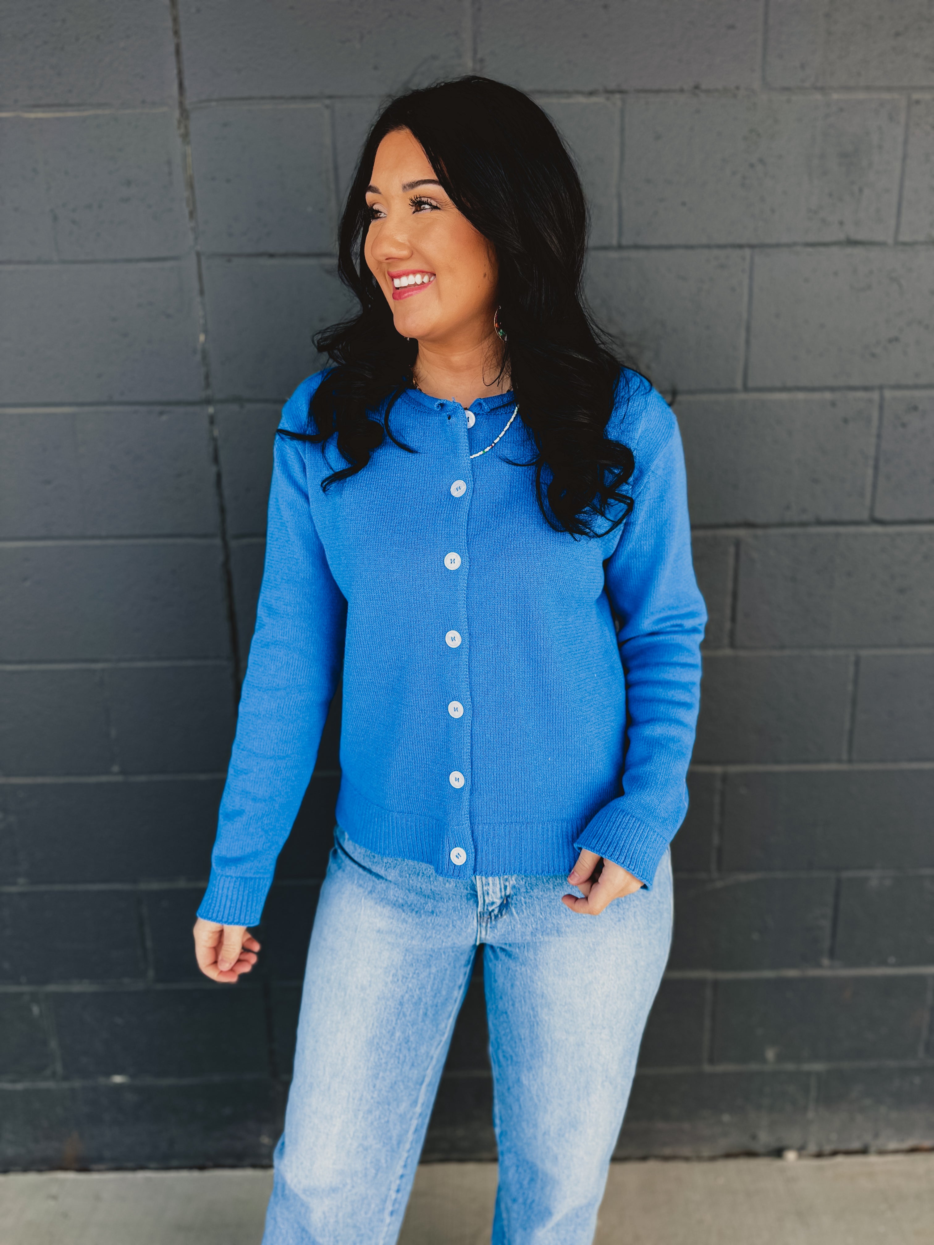 Raw rolled edge button up sweater cardigan with a round neckline in blue.