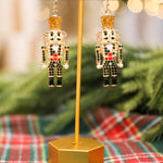Rhinestone and pearl detail nutcracker drop earrings with glitter details.
