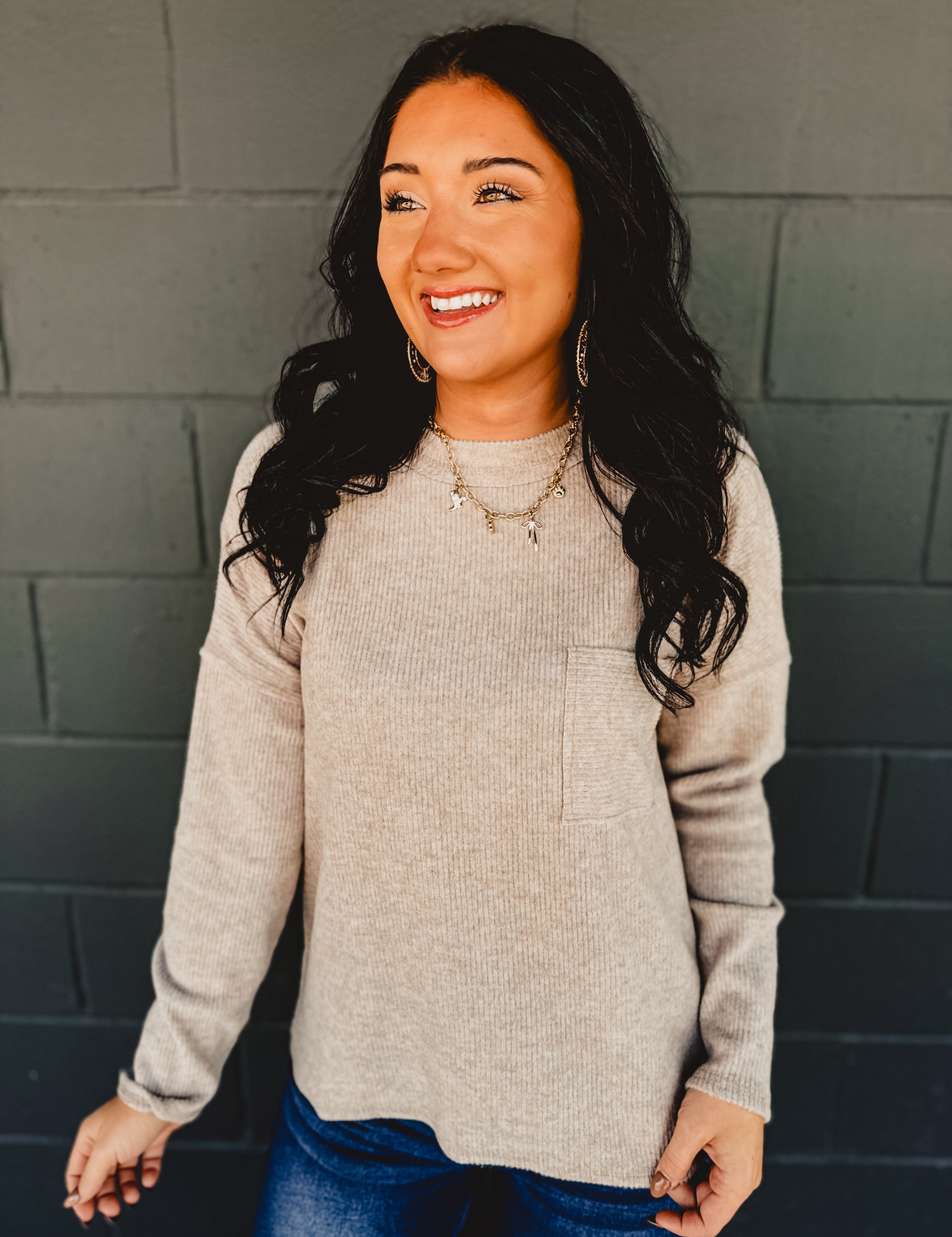 Ribbed brushed long sleeve top in taupe with a front pocket and exposed seams detail.