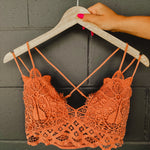 Terracotta colored lace crochet bralette with a scalloped edge and two straps on each side.