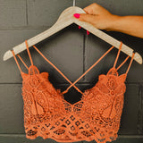 Terracotta colored lace crochet bralette with a scalloped edge and two straps on each side.