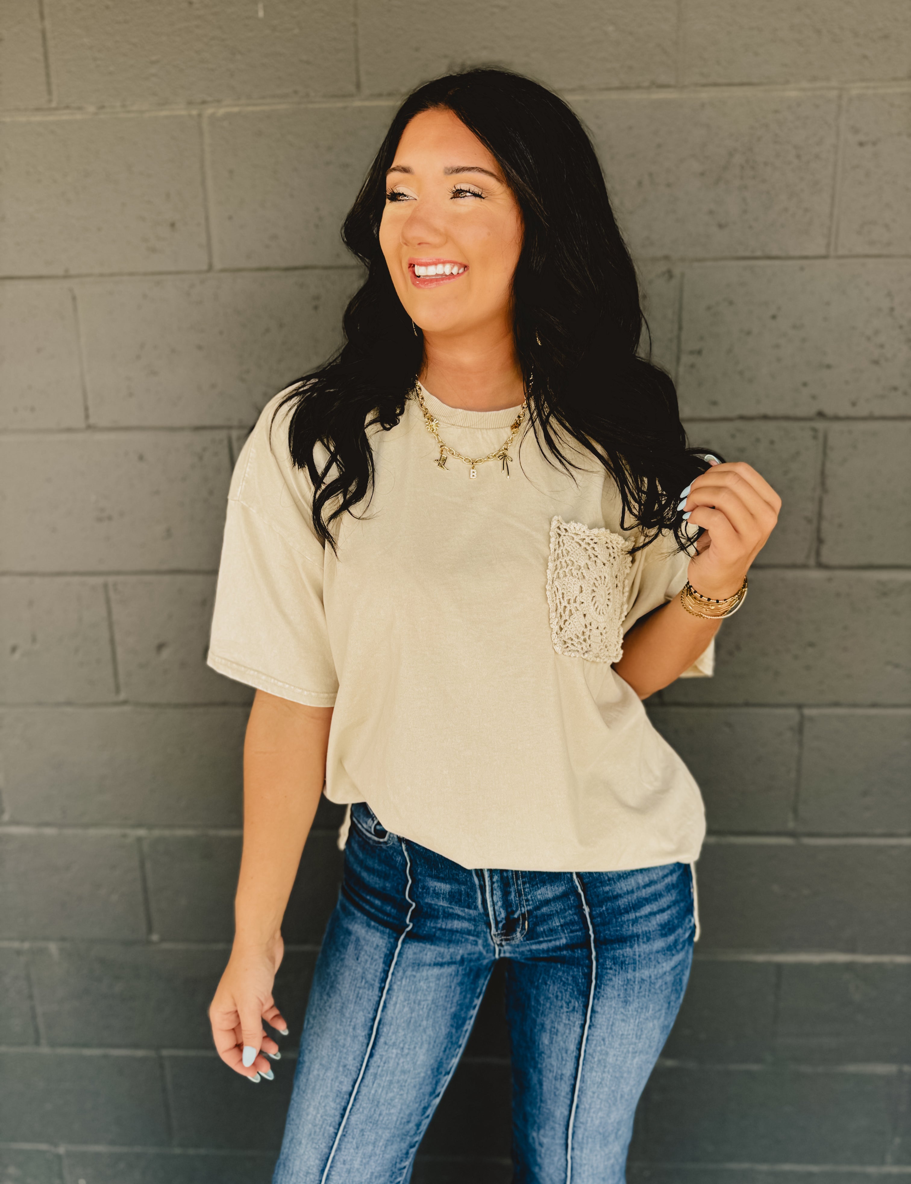 Short sleeved oversized top with drop shoulders, a front crochet pocket, and side slits in khaki.