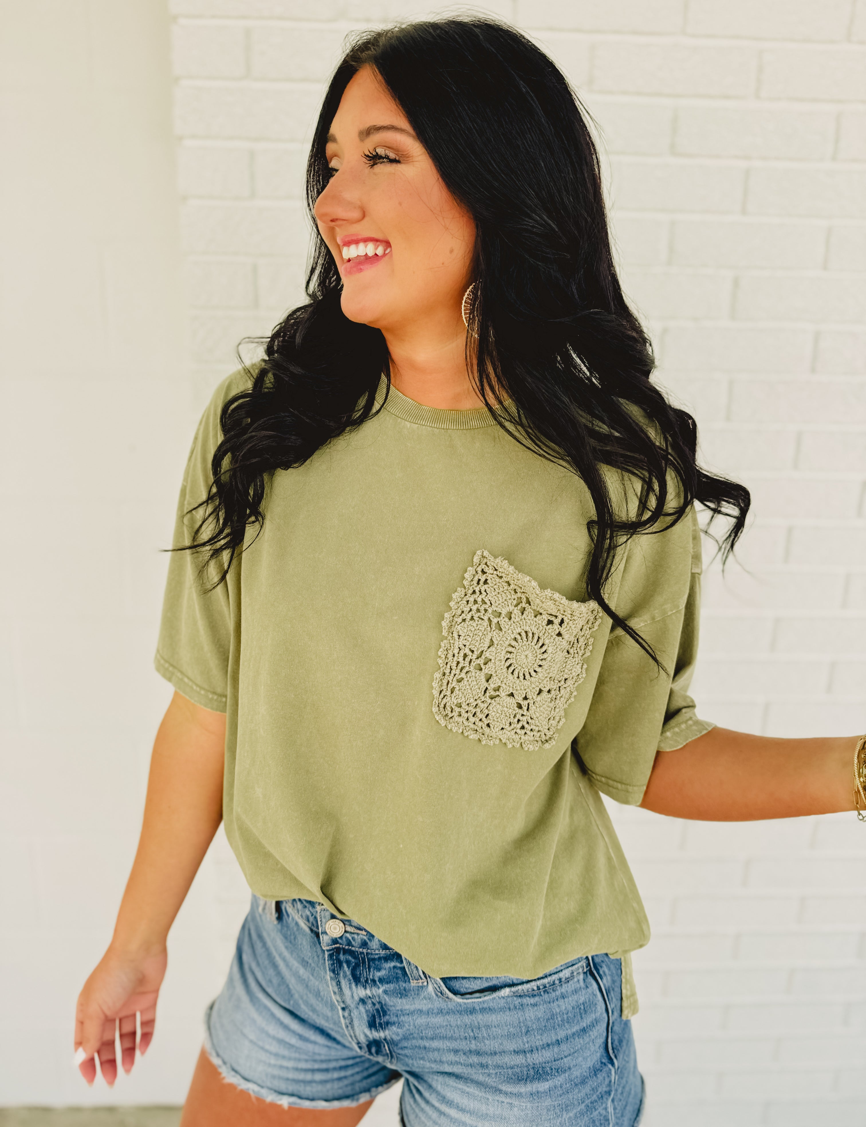 Oversized green top with crochet pocket with a boxy silhouette.