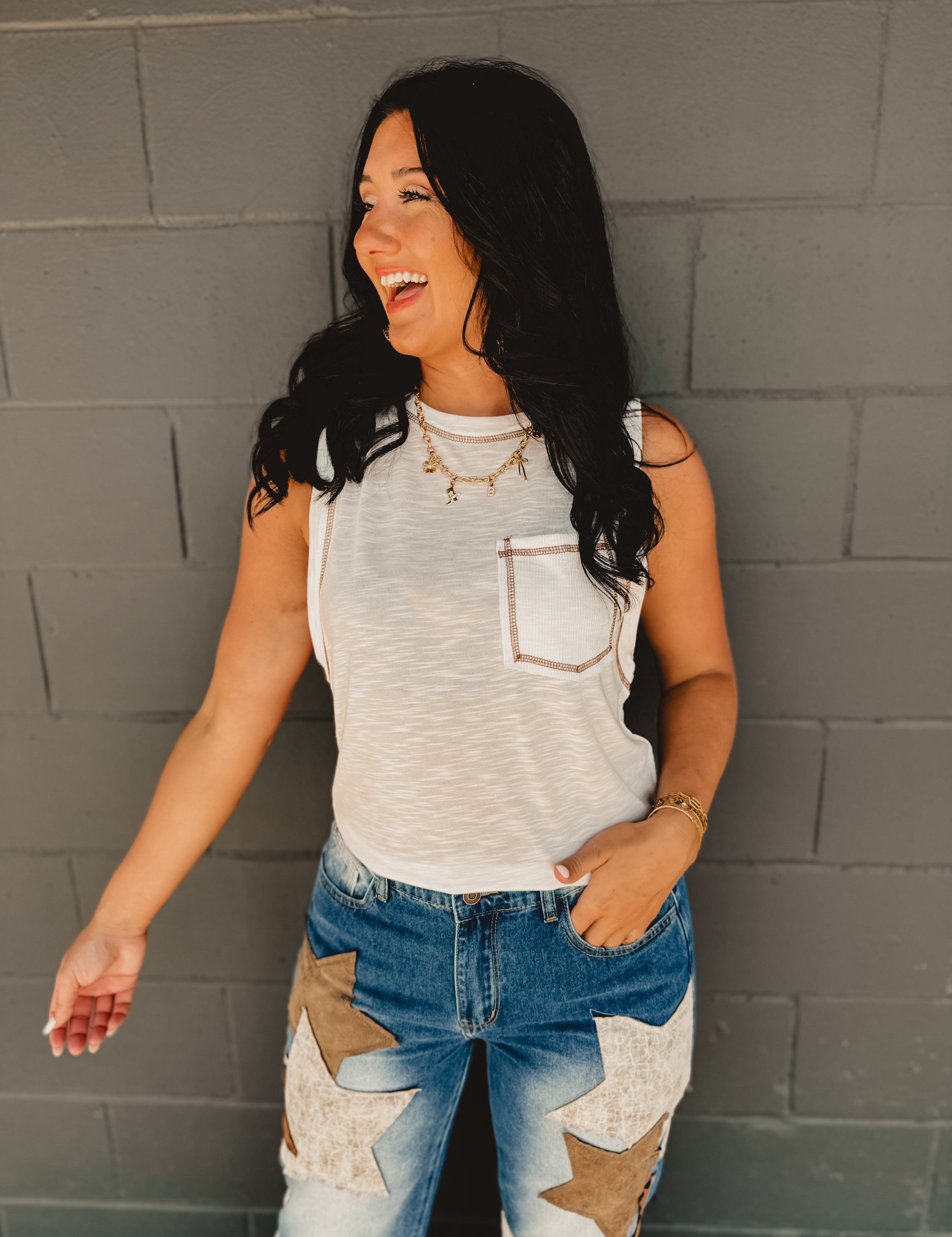 Sleeveless stitch detail and front pocket tank top in off white.