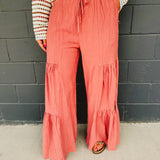 Tired textured wide leg pants with an elastic waistband and drawstrings in dried rose.