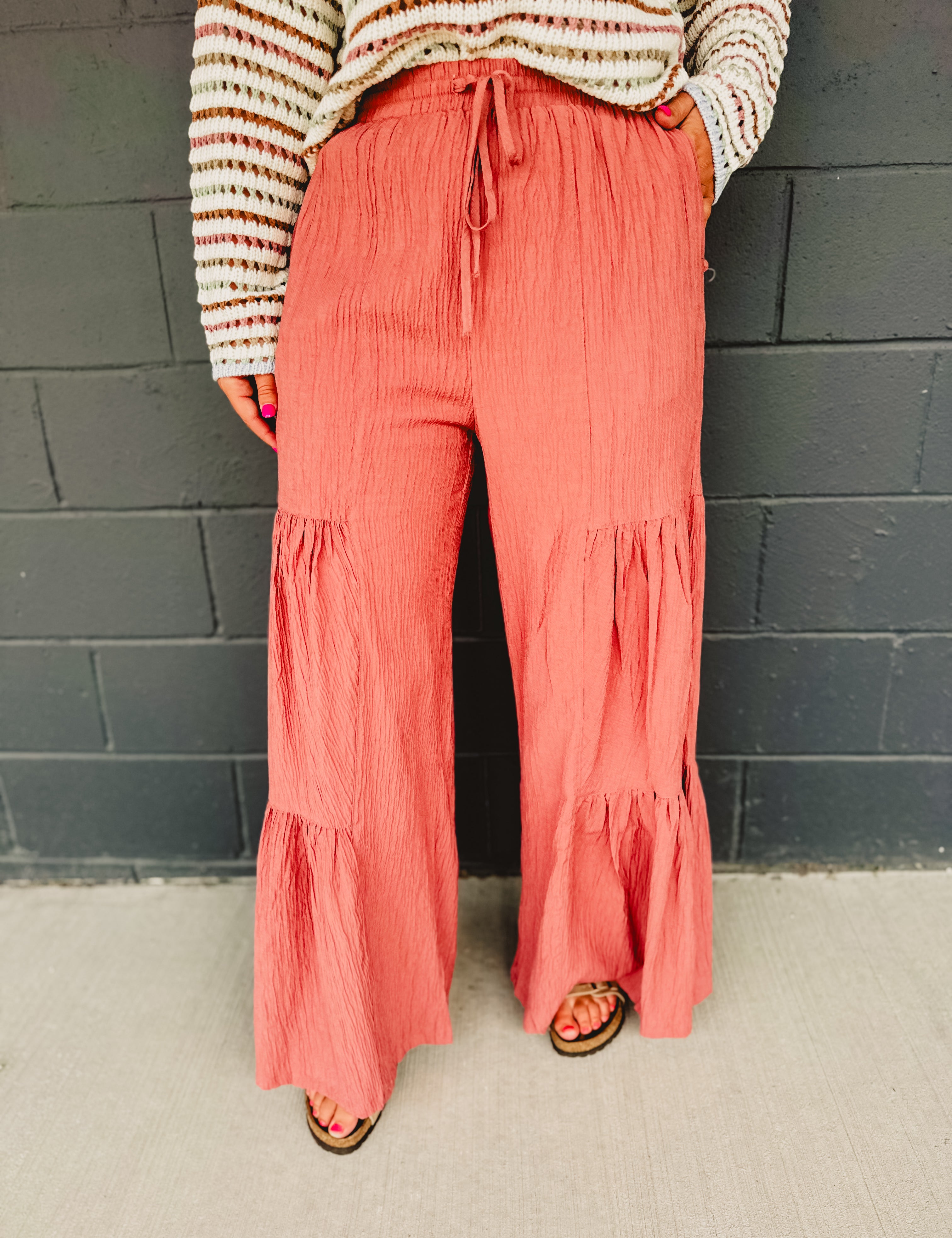 Tired textured wide leg pants with an elastic waistband and drawstrings in dried rose.