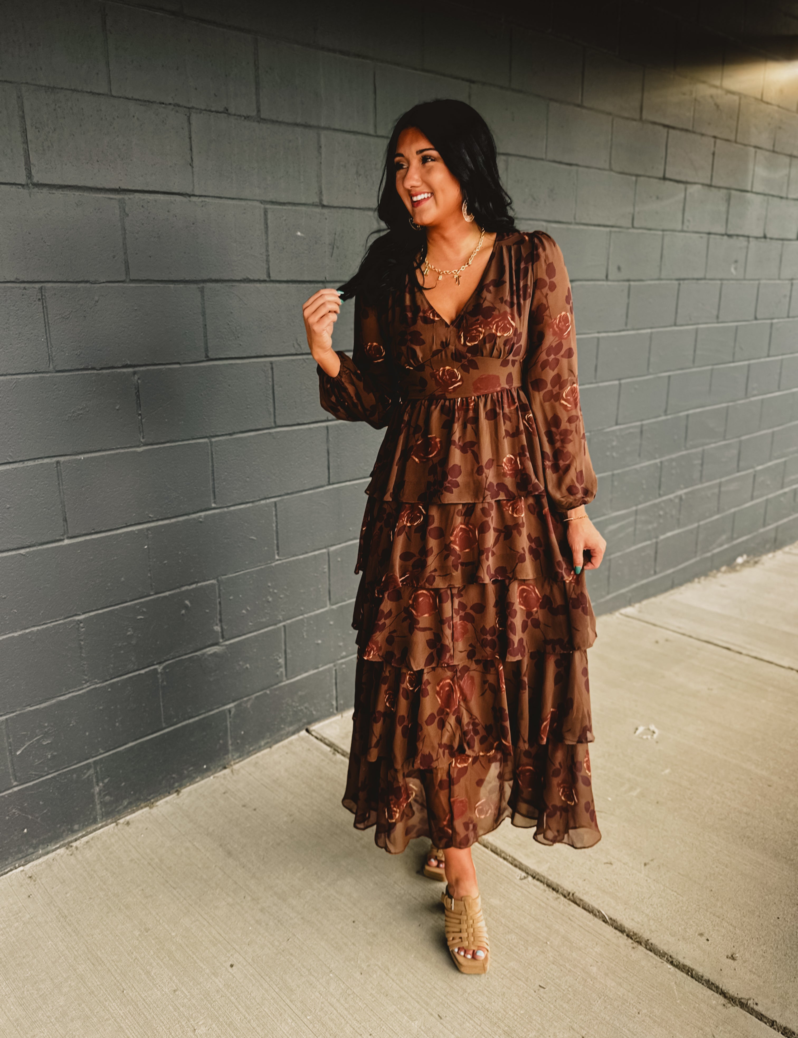 Long sleeved tiered brown floral maxi dress with a v-neck and fitted waistband.