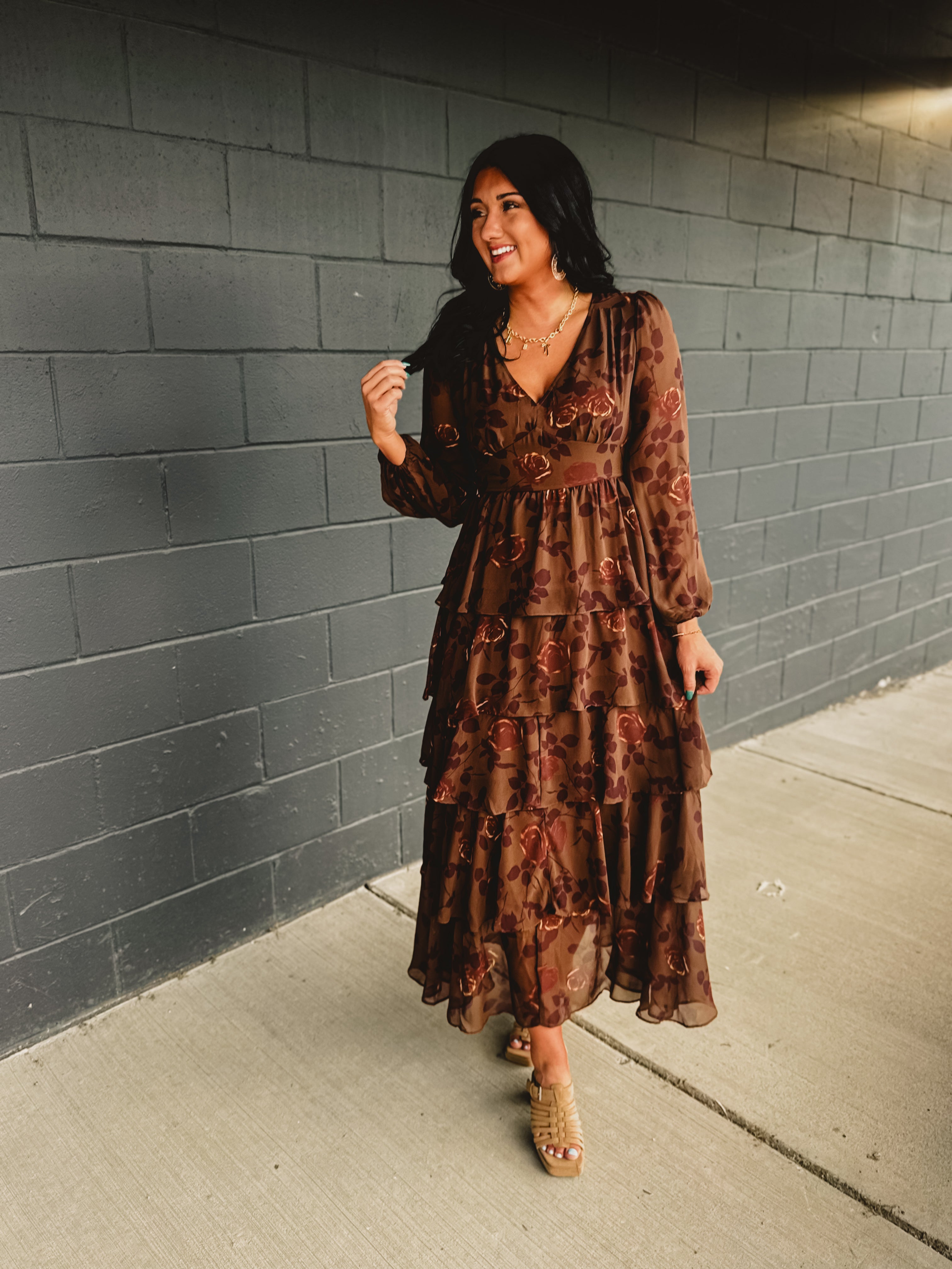 Long sleeved tiered brown floral maxi dress with a v-neck and fitted waistband.