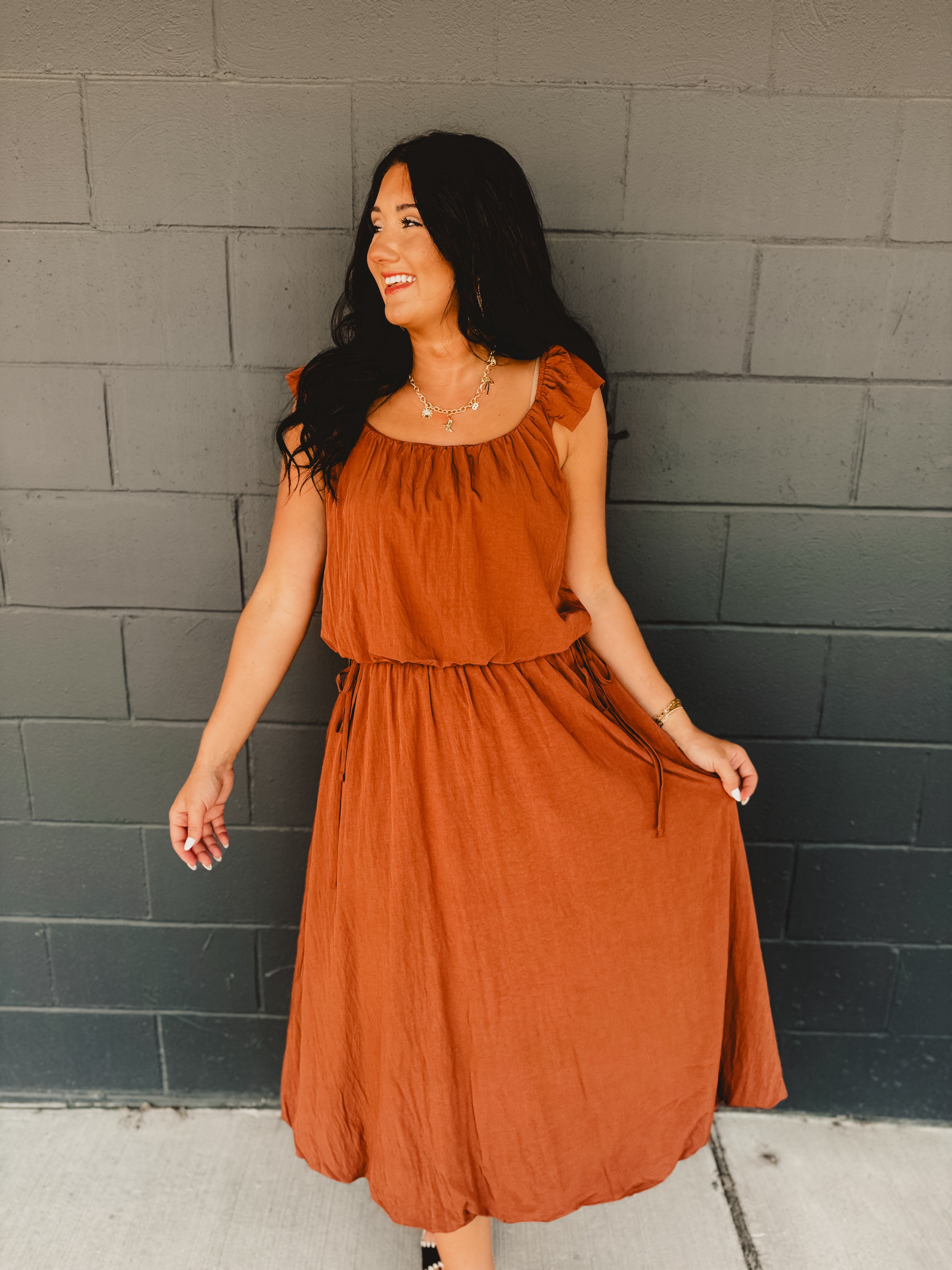 Rust colored bubble top and midi length skirt two piece set featuring side ties and flutter short sleeves.